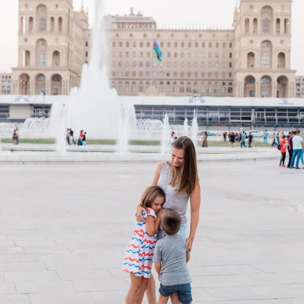 A mother strolling with her children at Baku Boulevard, a beautiful seaside park for families in Azerbaijan.