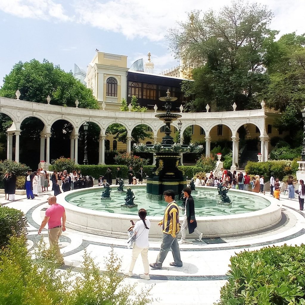 People relaxing and strolling through the lush, beautiful Philharmonic Garden in Baku, a perfect place to unwind