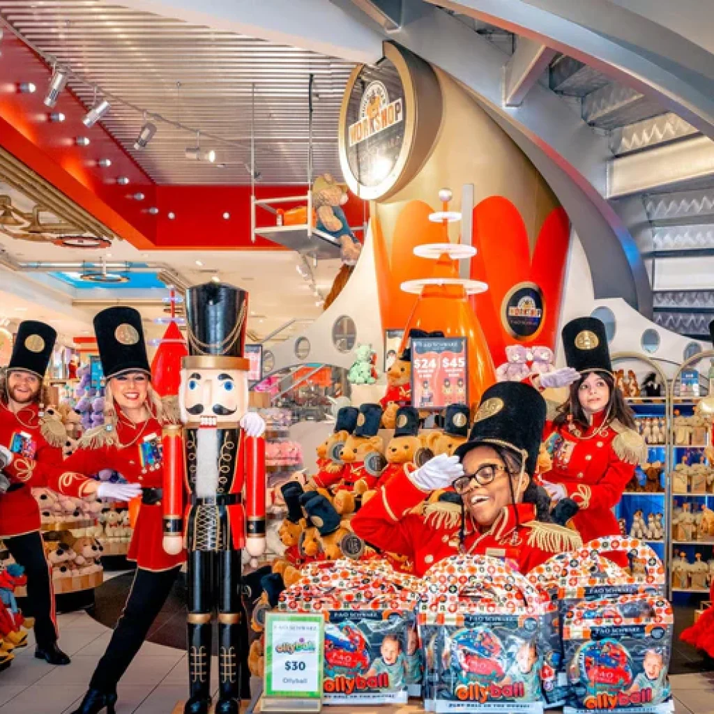 FAO Schwarz toy store in NYC with staff in red toy-soldier uniforms amid plush aisles and a spiral staircase
